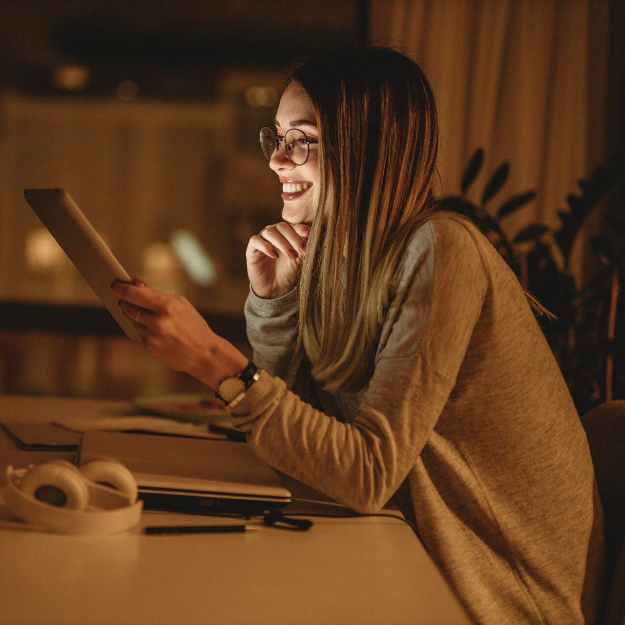 wormen smiling and working from home in a darkened room