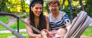Grandmother, mother, and baby girl enjoying quality time together in a park, highlighting the joys of family and childcare - for parent pathways support