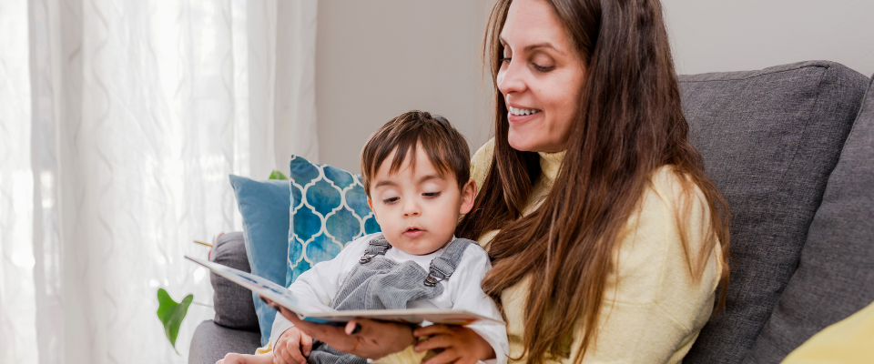 Mother and son on the sofa reading a book