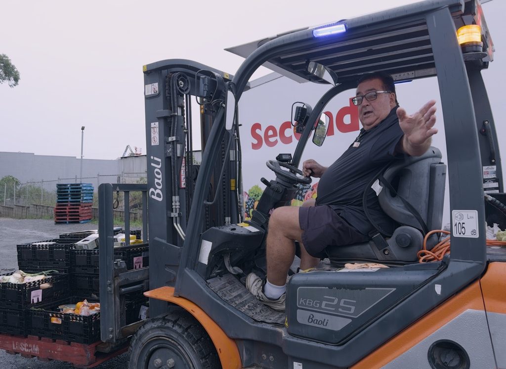 Pastor Phil Whiting operating a forklift during food-handling activities at New Life Foodbarn