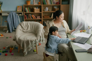 Women working at home with child playing nearby