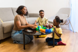 Mother and children enjoying quality time together, playing with colourful building blocks in the comfort of their living room